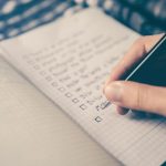 Travel Budget Planning - person writing bucket list on book