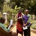 Safari Lodge - man in purple dress shirt holding white paper