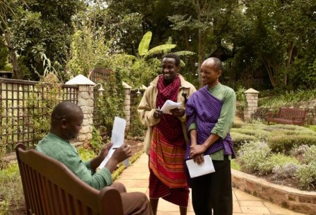 Safari Lodge - man in purple dress shirt holding white paper