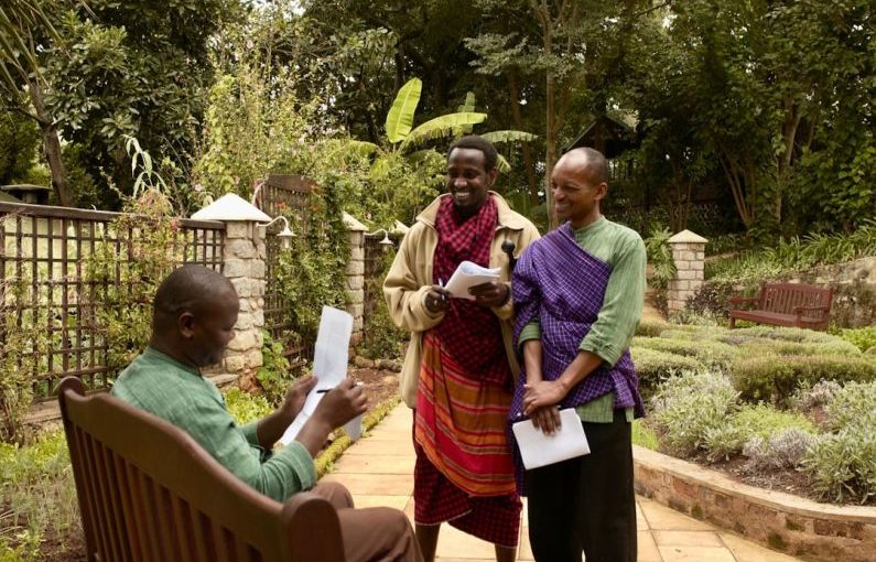 Safari Lodge - man in purple dress shirt holding white paper