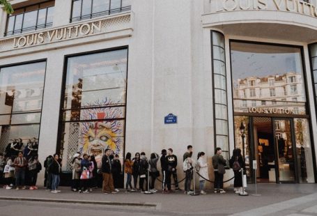 Luxury Shopping - people queuing beside Louis Vuitton store