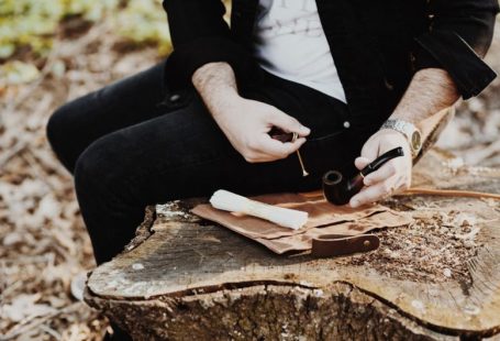 Bespoke Travel - man holding tobacco while sitting on wood slab