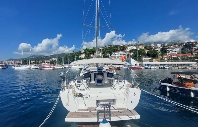 Yacht Charter - a sailboat docked in a harbor with other boats