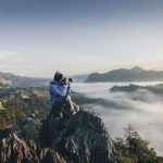 Travel Camera - man on top of mountain taking pictures