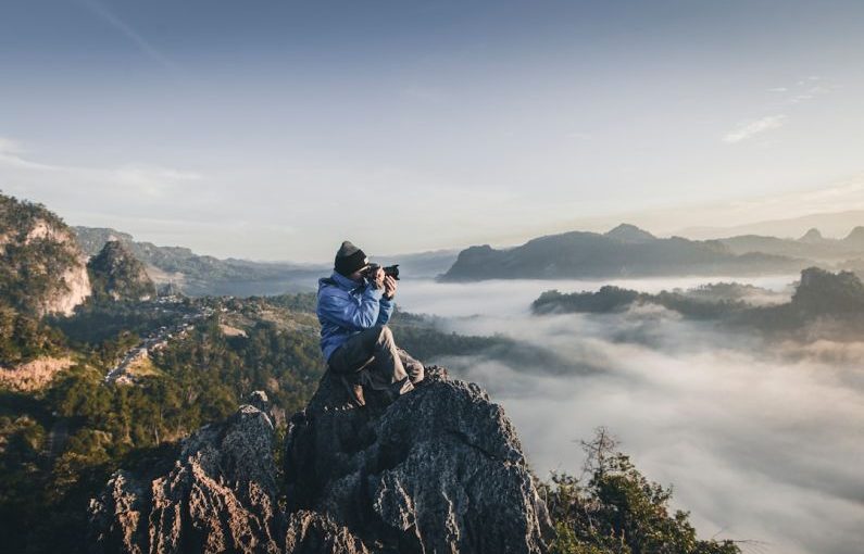 Travel Camera - man on top of mountain taking pictures