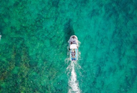 Travel Drone - aerial photo of white boat sailing on body of water at daytime