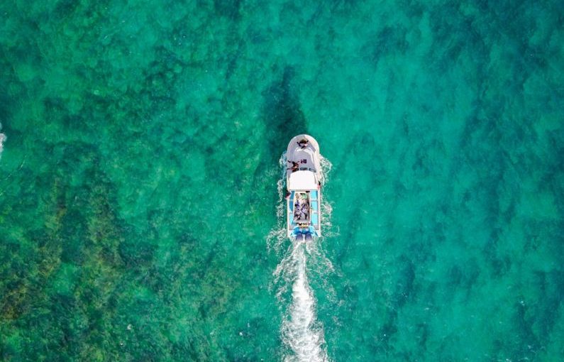 Travel Drone - aerial photo of white boat sailing on body of water at daytime