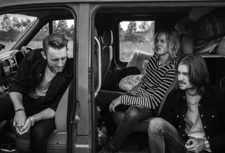 Travel Clothing - grayscale photo of three men sitting on vehicle seats