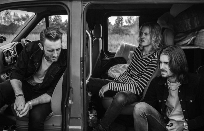 Travel Clothing - grayscale photo of three men sitting on vehicle seats