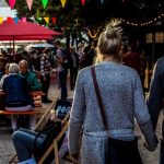 Food Festival - man and woman walking while holding hands during daytime