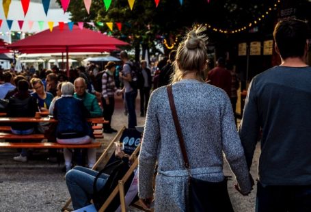 Food Festival - man and woman walking while holding hands during daytime