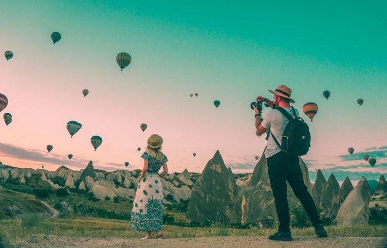 Luggage Travel - man taking photo of hot air balloons