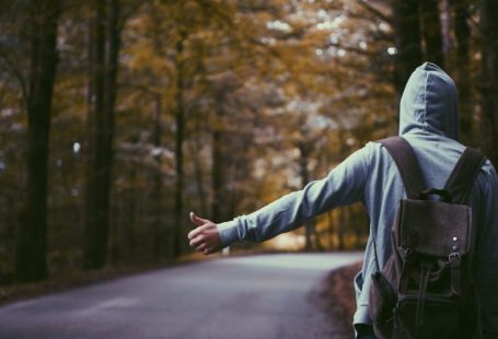 Solo Traveler - person standing beside road doing handsign