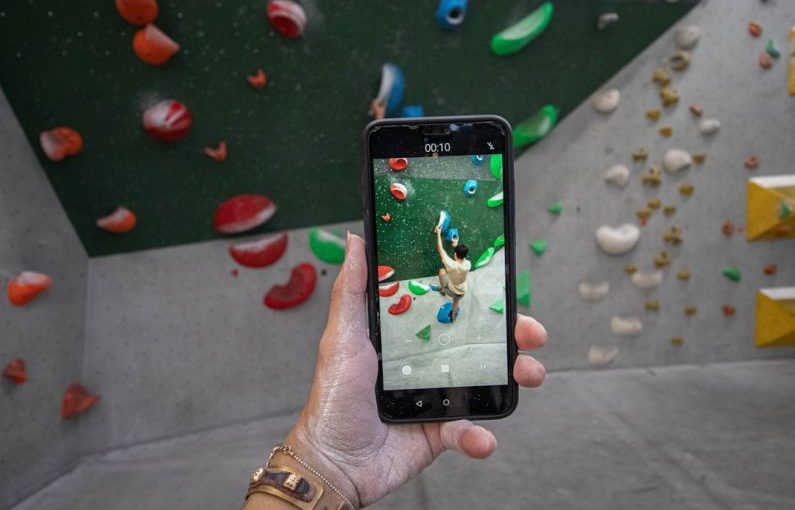 Smartphone Apps - a person taking a picture of a climbing wall