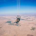 Skydiving Adventure - two men in 1 parachute in mid air during daytime