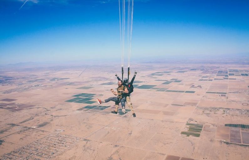 Skydiving Adventure - two men in 1 parachute in mid air during daytime