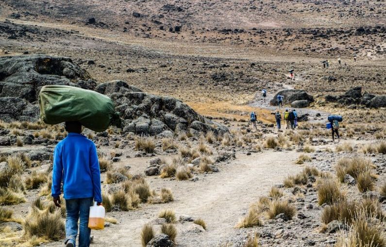 Kilimanjaro Climb - man carrying green sack