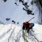 Ice Climbing - man wearing long-sleeved shirt climbing on mountain