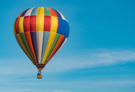 Hot Air Balloon - panning photography of flying blue, yellow, and red hot air balloon