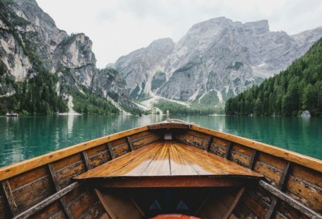 Planning Travel - brown wooden boat moving towards the mountain