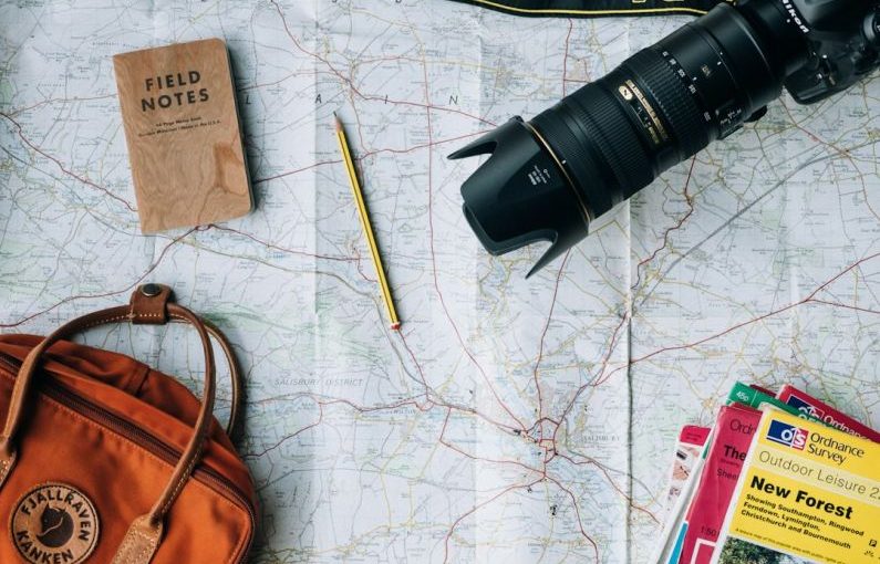 Backpack Trip - flat lay photography of camera, book, and bag