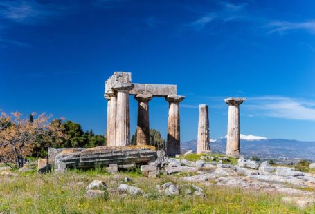 Ancient Ruins - gray concrete pillar on green grass field under blue sky during daytime