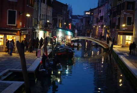 Local Cuisine - a canal in a city at night with a bridge over it
