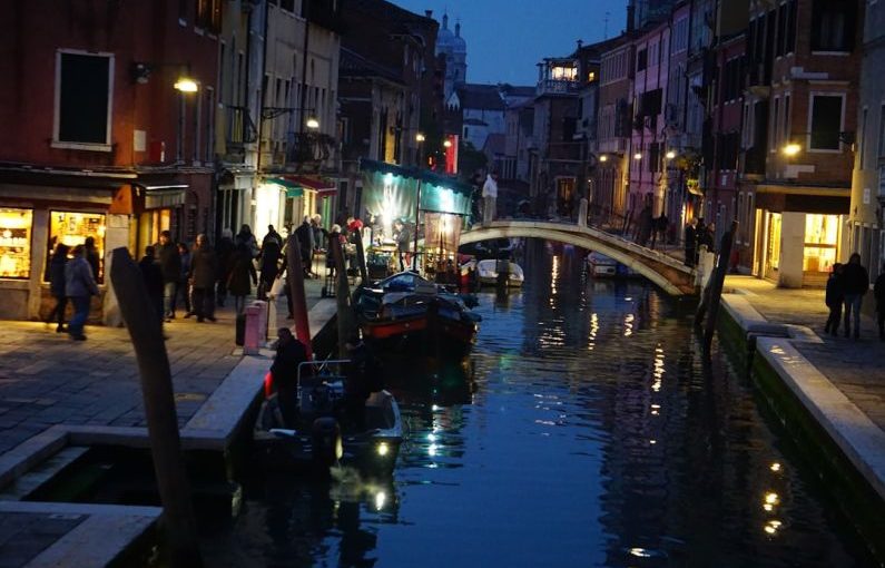 Local Cuisine - a canal in a city at night with a bridge over it