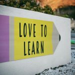 Language Learning - love to learn pencil signage on wall near walking man