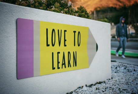 Language Learning - love to learn pencil signage on wall near walking man