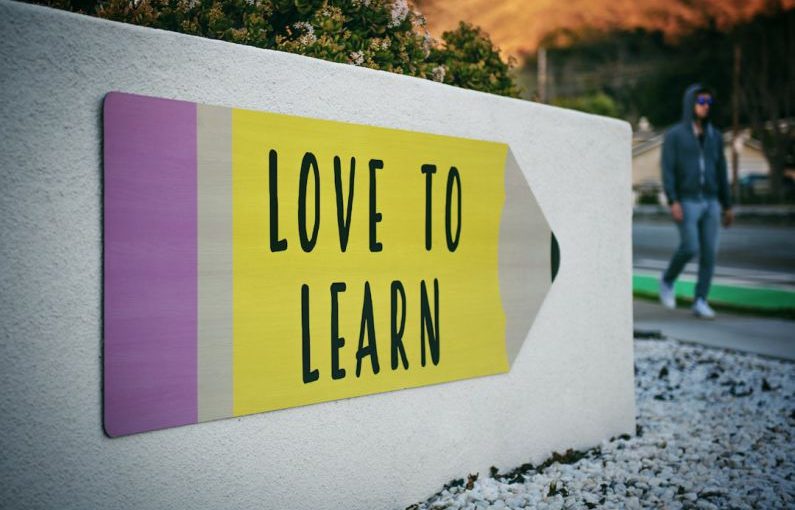 Language Learning - love to learn pencil signage on wall near walking man