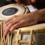 Traditional Music - a close up of a person playing a musical instrument