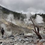 Eco Adventure - a man standing in a rocky area with steam coming out of the ground