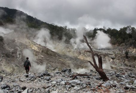 Eco Adventure - a man standing in a rocky area with steam coming out of the ground