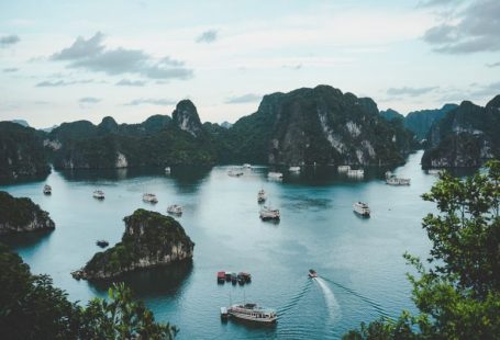 Eco Tour - high-angle photography of boats on water near hill during daytime