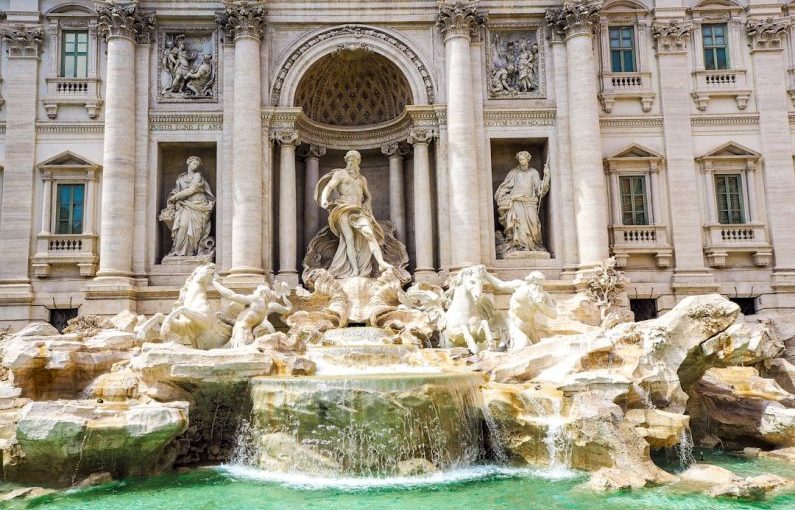 Budget Travel - a fountain in front of a building with statues on it